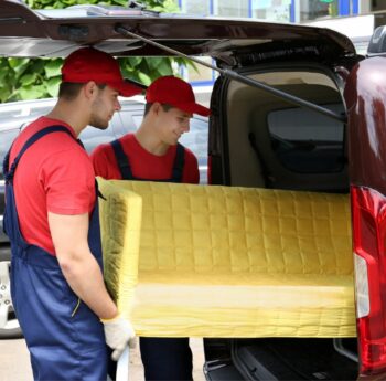 Günstig umziehen in Zwickau Günstig umziehen in Zwickau: Umzugshelfer laden ein gelbes Sofa in einen Transporter