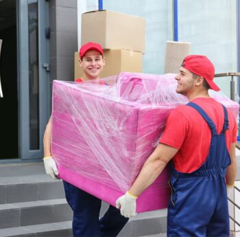 Umzug in Zwickau Zwei Umzugshelfer tragen ein in Folie gepacktes Möbelstück – Umzug in Zwickau